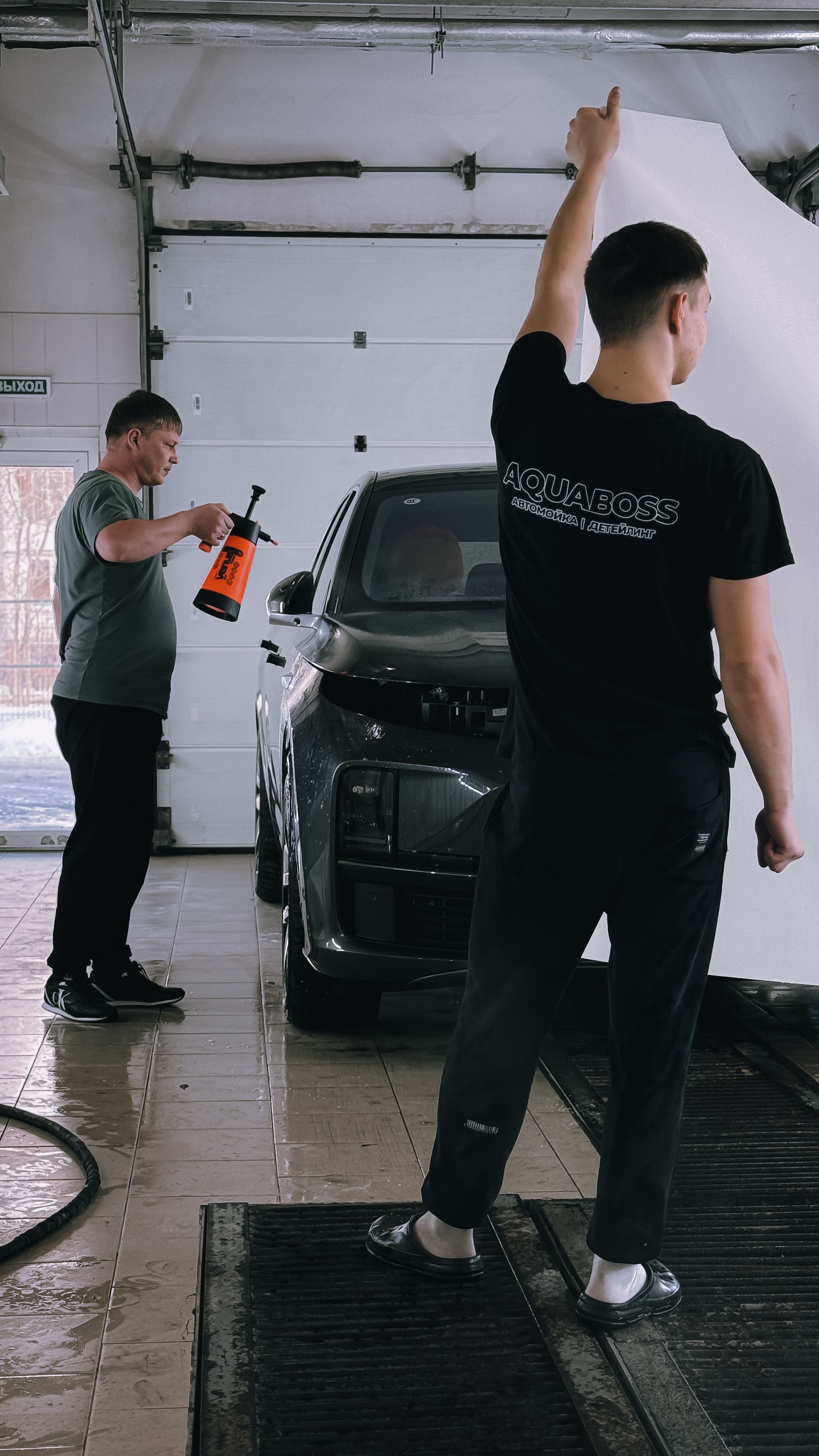 A vehicle being prepared and washed inside a professional detailing studio