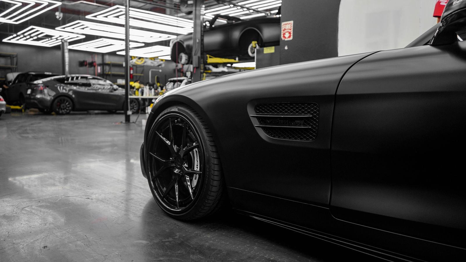 A clean dark performance vehicle presented inside an automotive studio